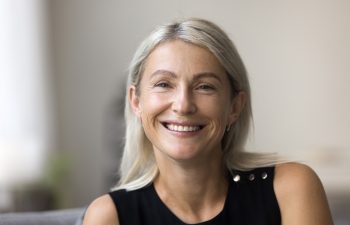 Head shot portrait 60 years old smiling grey haired lady on retirement looking at camera making video call enjoying happy life. Profile picture of beautiful stylish middle aged woman in social network